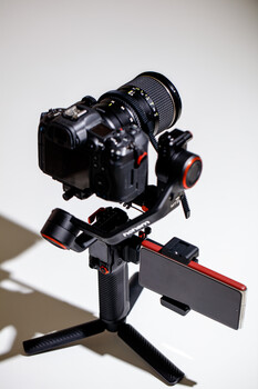 Professional cinema camera mounted on a motorized gimbal stabilizer with articulating arm and tripod base.