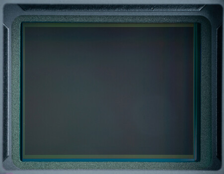 Vintage CRT monitor with dark display and teal-green bezel against gray background.