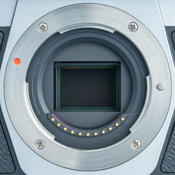 Camera body mirror and sensor assembly viewed head-on, showing the empty sensor cavity with surrounding metal contacts and mirror housing.