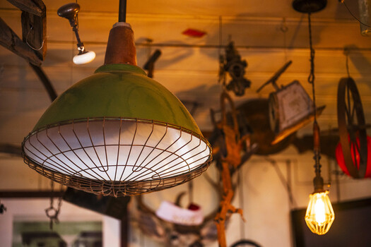 Vintage industrial pendant lamp with green dome shade and ribbed metal interior suspended in workshop space.