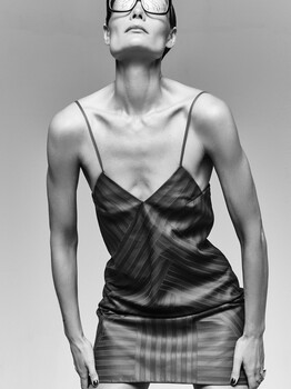 Black and white studio portrait of a person wearing oversized sunglasses and a draped camisole top.