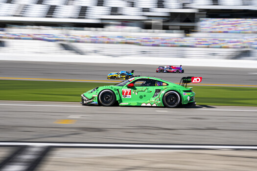 Bright green race car with number 11 on a racing track during competition.