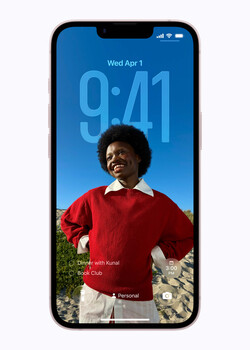 Smartphone lock screen displaying portrait of person in red shirt against blue sky background.