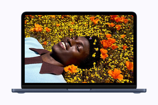 Person lying in a bed of yellow and orange flowers, looking upward with a serene expression.