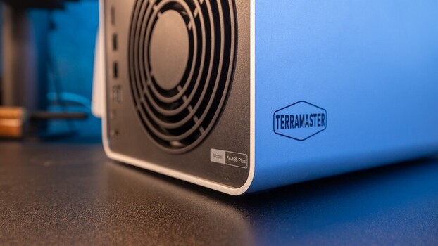 Close-up of a blue external hard drive with concentric circle vents and Terramaster branding visible.