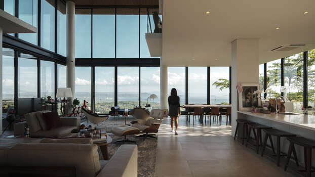 Modern high-rise residential interior with expansive windows overlooking a distant landscape.