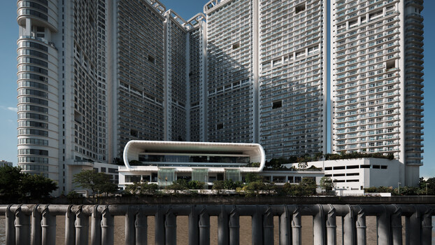 Modern curved white building with glass facade positioned in front of tall residential towers along a waterfront.