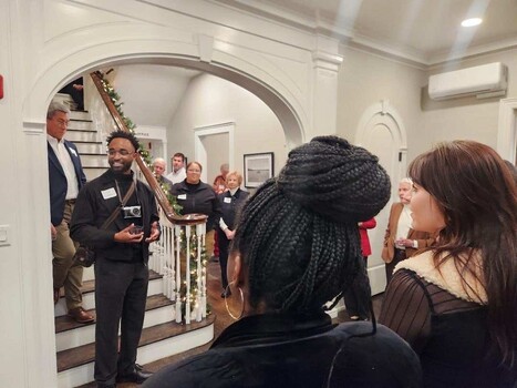 Attendees gathered in an elegant arched hallway during what appears to be a formal event or reception.