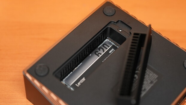 Close-up of camera battery compartment with battery inserted and orange background.