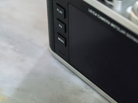 Close-up of portable device buttons showing Play, FF, and Menu controls on dark bezel.