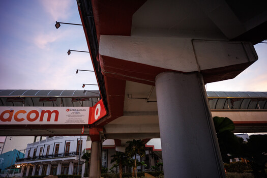Concrete overpass structure with red signage beneath twilight sky and architectural elements.