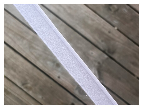 White fabric tape or ribbon laid diagonally across weathered wooden boards.
