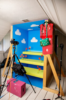 Professional product photography setup with colorful backdrop, lighting equipment, and camera on tripod.