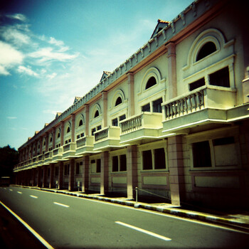 Classical colonial-era building facade with symmetrical arched windows and ground-level arcades