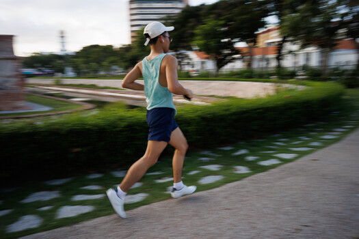 Male runner in motion on an urban pathway with motion blur effect