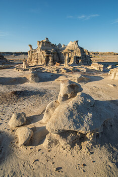 Eroded sandstone rock formations in desert landscape with golden hour light