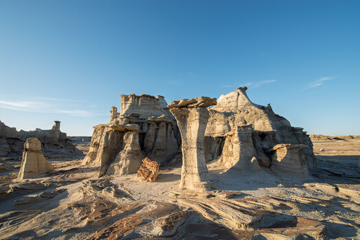 Eroded sandstone formations with columnar pedestals in arid desert landscape