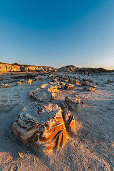 Rocky coastal shoreline at golden hour with illuminated boulders in shallow water