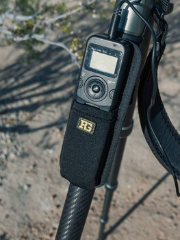 Handheld audio recorder with LCD screen mounted on camera hotshoe with shoulder strap