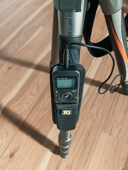 Flash trigger device with LCD display mounted on camera hot shoe, shown on wooden surface