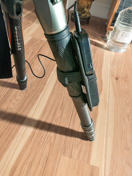 Hair styling tools arranged on wooden floor including blow dryer, flat iron, and curling iron with cord