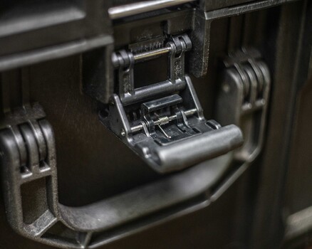 Close-up of a metal latch mechanism on camera or equipment case