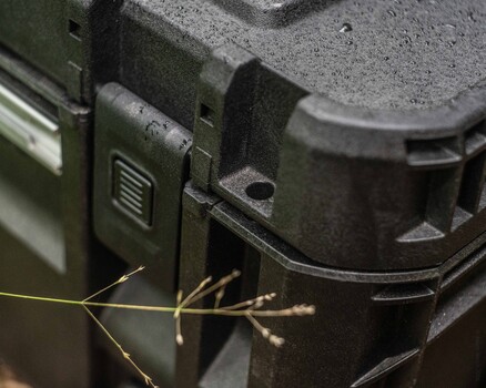 Close-up of camera equipment with dried plant material positioned in foreground