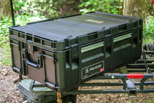 Pelican hard case gear storage box mounted on trailer with forest background