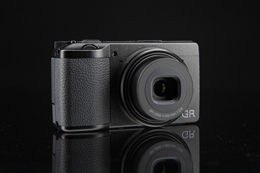 Ricoh GR compact digital camera with grip extension against black background