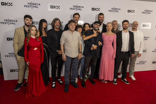Large group of people posing together on a red carpet in front of Tribeca Festival and DKX branded backdrops