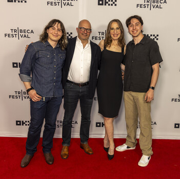 Four people posing together on a red carpet at Tribeca Film Festival