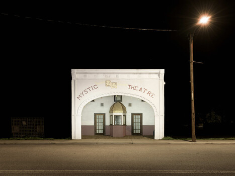 Exotic Theatre building illuminated at night with vintage architectural facade
