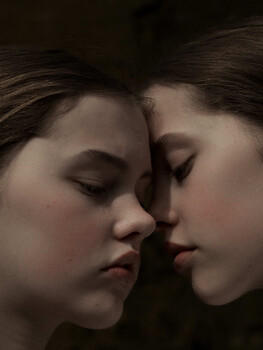 Two faces in profile with foreheads nearly touching, eyes closed in intimate proximity