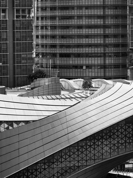 Black and white architectural photograph of modern curved building facade with grid windows