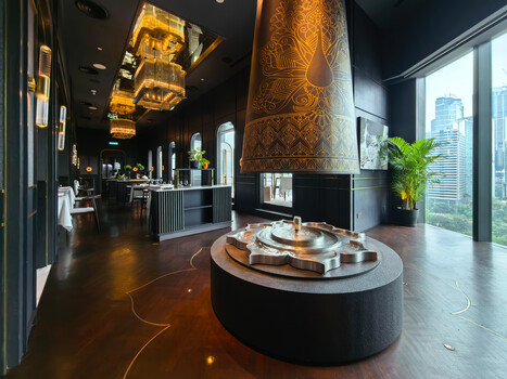 Modern luxury hotel lobby with dramatic ceiling lighting and central sculptural display