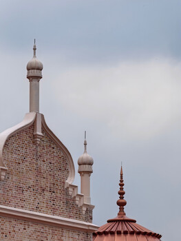 Islamic architecture featuring ornate domes and minarets against overcast sky