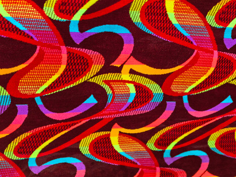 Abstract illustration of interlocking colorful gradient ribbons in red, yellow, cyan, and purple on dark background
