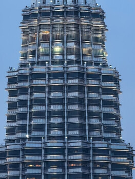Modern residential high-rise tower photographed from below against clear blue sky