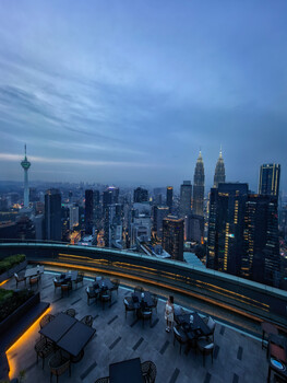 Kuala Lumpur skyline at dusk with rooftop terrace in foreground