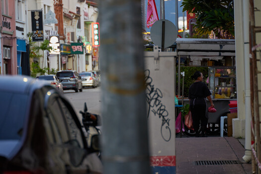 Urban street scene shot through foreground pole with selective focus depth of field