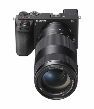 Sony α mirrorless camera with attached telephoto zoom lens, displayed against white background