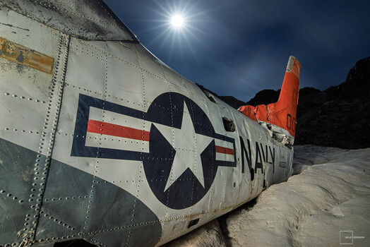 Low perspective allows us to see the moon over this Navy plane.