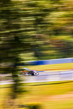Race car captured with motion blur panning technique on a racetrack