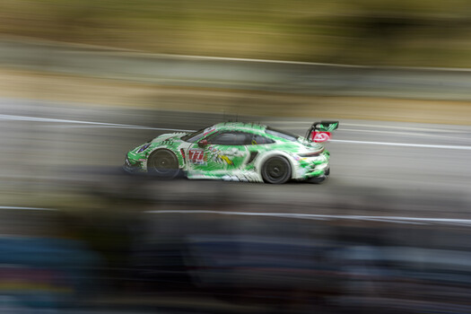 Green and white race car in motion blur on track