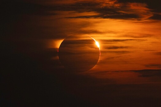 Solar eclipse with diamond ring effect and golden sky