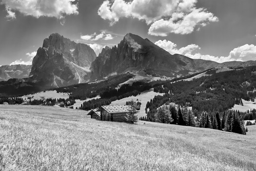 Black and white mountain landscape with dramatic peaks and rolling meadows in Alpine valley