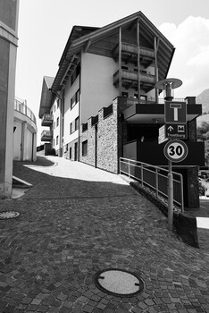 Black and white street scene with modernist architecture and speed limit sign