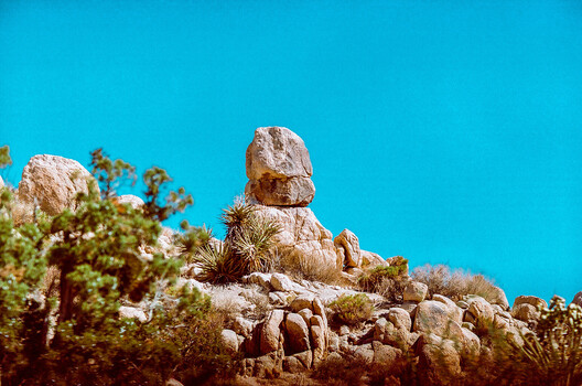 Balanced rock formation against clear blue sky in desert landscape