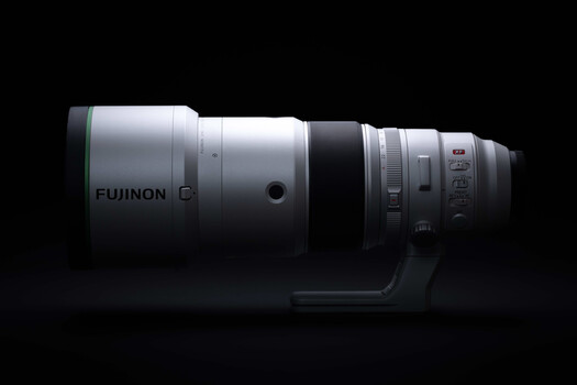 Fujinon C telephoto lens mounted on studio backdrop against black background