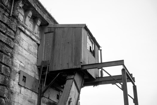 Industrial metal structure with corrugated siding attached to weathered stone building